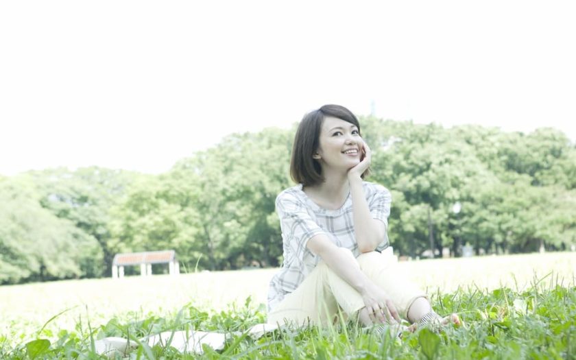 原っぱに座る女性